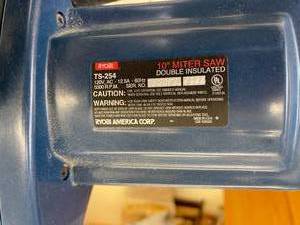 lot 55 image: Ryobi 10 Inch Electric Mitre Saw with Rolling Bench