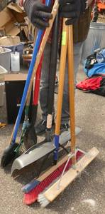 Collection of brooms, shovels, rake
