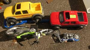Lot of toy trucks and motorcycles and lacrosse stick and hard hat