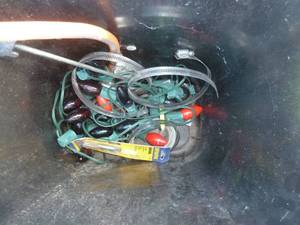 waste basket of christmas lighs, mosquito bait and nets