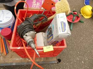 milk crate with gloves, brush, caulk gun, drill, extension cord, pry bar, log splitting wedge, Raid