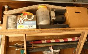 Upper garage shelf with electric Saw, garden and lawn chemical, fishing spear, flag