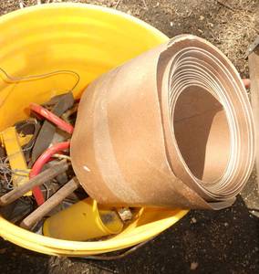 Bucket with misc tools, big roll of sand paper, light