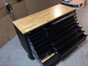 lot 112 image: 62 in. W x 24 in. D Heavy Duty 14-Drawer Mobile Workbench Tool Chest with Adjustable Height Wood Top in Matte Black by Husky Customer Returns See Pictures