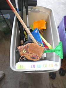 lot 51 image: Large tote of toys, bats, gloves, hockey stick, game of life