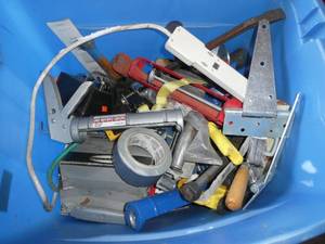 lot 71 image: Tote of caulk guns, hinges, ratchet, pry bar and misc tools