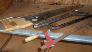 lot 189 image: Shelf with big clamp, saw, wrench, pry bar,