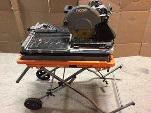 lot 112 image: Ridgid 10-in. table saw with stand in good condition customer returns see pictures