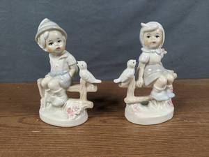 lot 410 image: Pair of Little Boy & Girl Porcelain Figurines Sitting on Fence with Bird - V