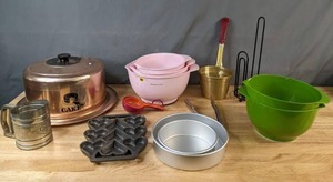 lot 370 image: Assorted Kitchen Baking Items Covered West Bend Cake Dish, Kitchen Aid Mixing Bowls, Cast Iron Heart Molds, Flour Sifter and More - V
