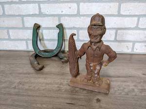 lot 605 image: Cast Iron 10 Statue - Man next to giant ear of corn  (2) Horseshoes