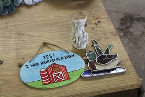 lot 1117 image: Lot of (3) Home Dcor - Yes I Was Raised In A Barn Wall Dcor, Stained Glass Duck, Angel Statue