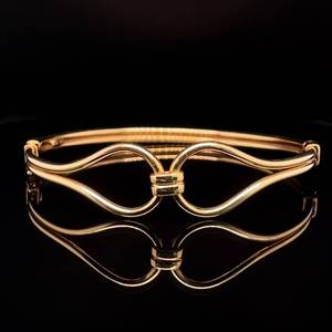 lot 63 image: Romantic Beauty Love Knot Open Wire Hinged Oval Bangle Bracelet in Yellow Gold