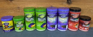 lot 791 image: NEW 8 Containers of Omega One Cichlid Food Large, Medium and Small Pellets, Veggie, Veggie Kelp, Super Color and More