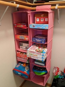 lot 118 image: Large Assortment of Games and Hanging Organizers Candyland, Chutes & Ladders, Connect 4, Wits & Wagers, Rack O, Sequence, Uno, Puzzles and More