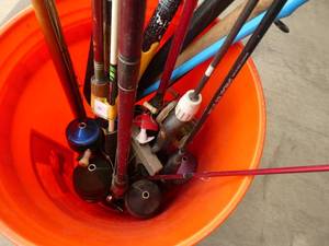 Bucket full of fishing rods and reels