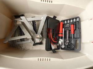 Tote with 2 jack stands, a car emergency kit with jumper cables and a bottle of windshield washer fluid