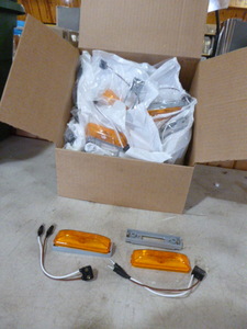 lot 98 image: Case of Peterson Manufacturing Amber Marker Lights