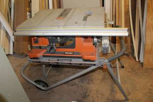 lot 1 image: Ridgid TS2400-1 Collapsible Table Saw with Ridgid Work-N-Haul It Two Wheel Work Stand