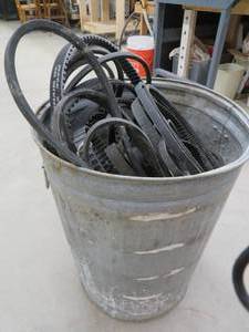 METAL GARBAGE CAN FULL OF BELTS