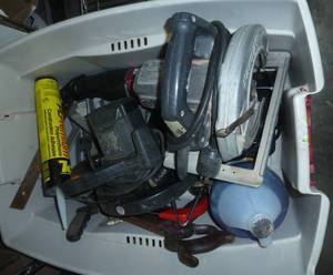 Tote full of garage tools, circular saws, hand saws, jack stands, washer fluid