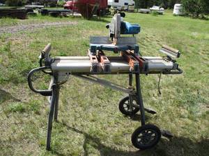 lot 117 image: Ryobi 10 Miter Saw on Ridgid Stand with manual. Powered on and works.