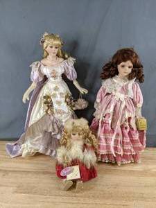 lot 342 image: Collectible Dolls Elegant Young Lady in Lavender, Ruby Haired Lass in Pink, Wintry Waif in Red is also a Music Box Q