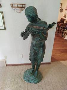 Large metal statue holding bird-bath