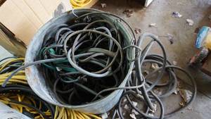lot 43 image: Galvanized garbage can of bungee cords and miscellaneous hoses