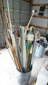 lot 135 image: Galvanized garbage can full of you name itbrooms, metal rollers, yard sticks, mops, vintage golf clubs etc.