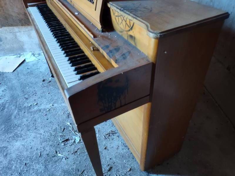 Upright piano with artwork on top