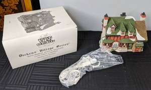 lot 404 image: Heritage Village Collection, Dickens Village Series, Ruth Marion Scotch Woolens Lighted Ceramic Building, 1989
