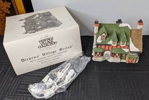 lot 408 image: Heritage Village Collection, Dickens Village Series, Ruth Marion Scotch Woolens Lighted Ceramic Building, 1989