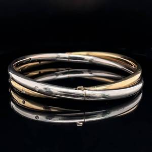 lot 90 image: Chic and Versatile Diamond-Studded Dual Yellow and White Entwined Round Bangle Bracelet in 14k Two-Toned Gold VIDEO