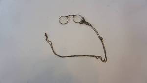 lot 122 image: Wow Sterling silver()marked 800 folding eyeglasses circa early 1900shas heavy engraving and some pierced filigree patterns on handle With a 40 inch chain