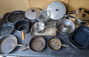 lot 212 image: Plenty of Pots and Pans Cast Iron Skillets, Pots, Pans, Lids, Colander, Baking Pan, Cutting Board, Roasting Pan And More