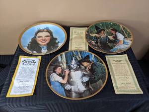 lot 314 image: Dorothy Portraits from Oz Plate Collection 3847C, The Tin Man Speaks The Wizard of Oz Commemorative Plate Collection 2268G and Dorothy Meets the Scarecrow The Wizard of Oz Commemorative Plate Collection 2229H by The Hamilton Collection Decorative Plates