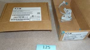 lot 125 image: New Eaton parts, 2 PKE-SWD-32 switches, and a DXE-EXT-SET module