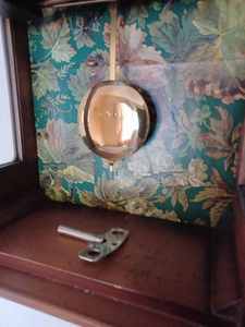 lot 7 image: Tradition Tempus Fugit Wind-up Wall Clock with Key, 10.25 inches wide by 21 inches tall by 5 inches deep