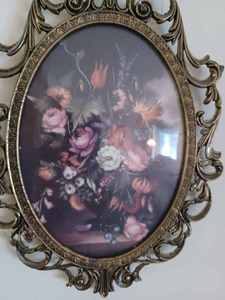 lot 26 image: Pair of Small Plastic Framed Oval Pictures of Flower Vase Displays, 10-inches long by 7.25-inches wide