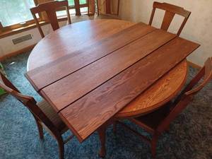 lot 136 image: 53.5-inch Round Oak Table with 3-Leaves and Six Chairs, One Table Leg was Repaired by a Furniture Repair Shop
