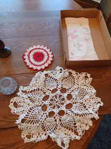 lot 242 image: 13 New Candles, 4-Candle Holders, Three Doilies, Pair of Cloth Place Mats, and New Wax Candle Adapters
