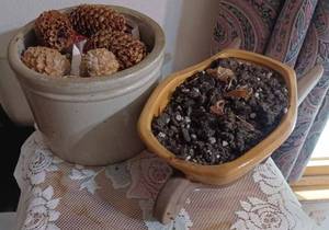 lot 271 image: Ceramic Wheelbarrow Planter and a Small Crock Jar of Pine Cones - has Hairline Crack
