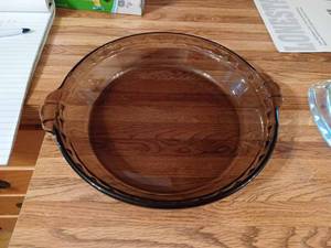 lot 344 image: 4-Pie Plates Dark Pyrex 9.5-inches, LOvenware Deep Pie Plate 9-inches, Two Clear Pie Plates - Both are 8-inches