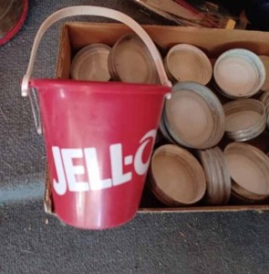 lot 387 image: Box of Ball Mason Canning Jar Lids with White Enamel Centers, Jell-O Plastic Sand Bucket, and 2-Ridgeview Water Mugs