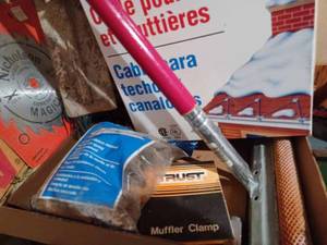 lot 491 image: Box of Hardware Cement Trowel, Roof and Gutter Cable, Muffler Clamps, Rat Trap, New Duraflame Log, and More