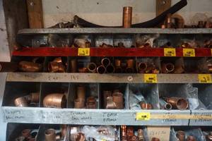 lot 26 image: Wall Mount Metal Partitioned Storage Rack With Assorted Copper Fittings