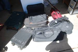 8 pieces of luggage. Most have whee...