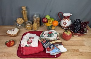 lot 117 image: Assortment of Kitchen Table Dcor Glass Fruit Bowl, Waverly Pitcher, Venetian Apple Dish, Glass Storage Containers with Noodles, Wash Cloths, Oven Mitts and More W