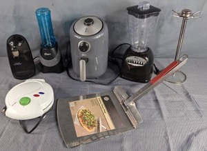 lot 269 image: Kitchen Goodies New Grill Shop Pizza Peel, DASH Air Fryer, (2) Oster Blenders, Utensil Stand, Tasty Baker Toy Story Waffle Maker, Black & Decker Can Opener  Z